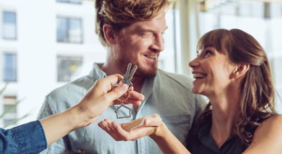 Young couple receiving keys for their new home