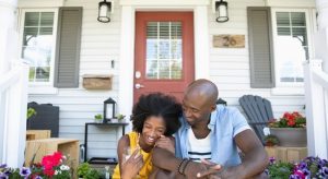 Couple sitting in front of their home