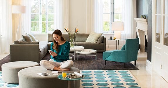 Woman sitting in sofa while using phone