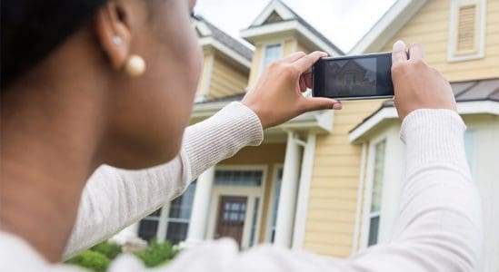 Woman taking a photo of a house