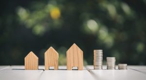 Toy model houses and stack of coins