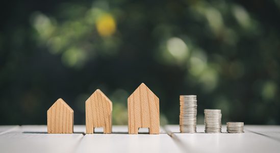 Toy model houses and stack of coins