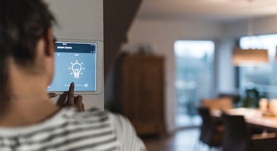 Woman turning on light using an tablet