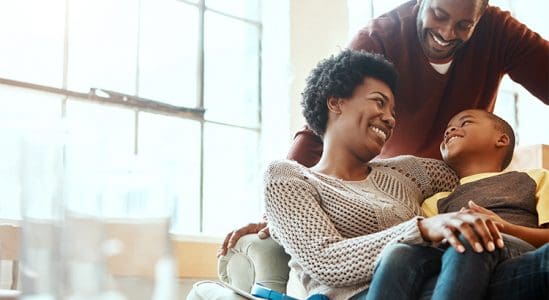 Couple with their son while laughing in sofa