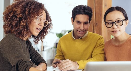 Professional discussing with young couple using a laptop