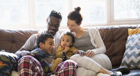 Couple with their small kids in sofa
