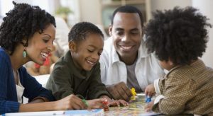 Couple with their 2 kids playing on the table