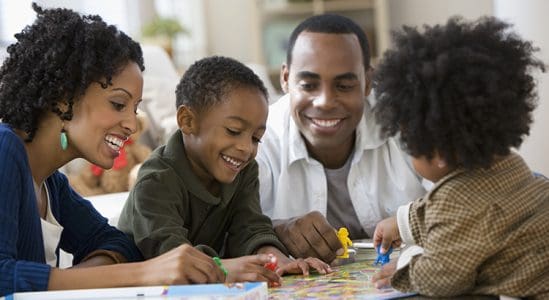 Couple with their 2 kids playing on the table