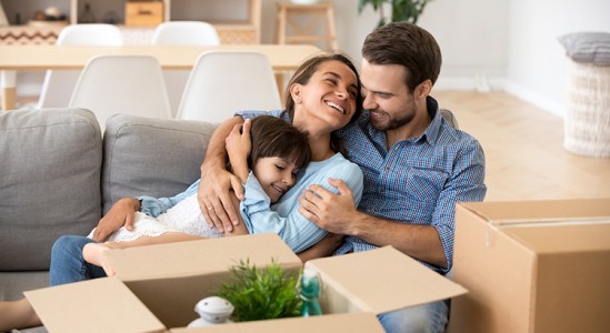Mom, dad and son hugging each other at sofa
