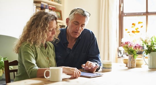 Senior couple using tablet in the table