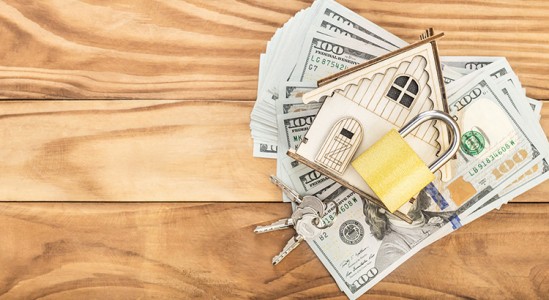 Toy model house with dollar bills