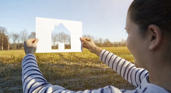 Woman holding a paper with house shape