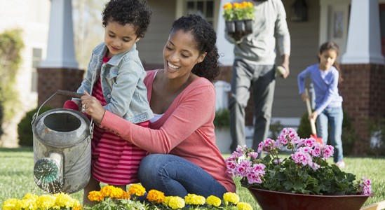 Mom and daughter watering plants