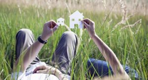 Man holding paper model house