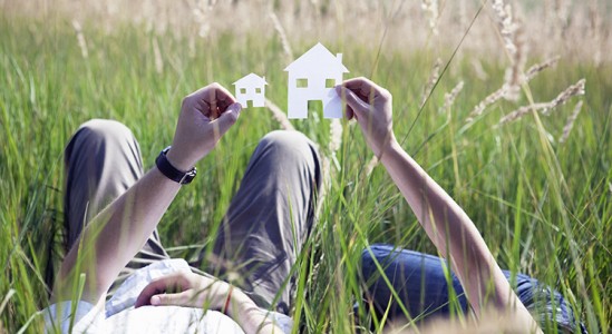 Man holding paper model house
