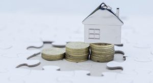 Stack of coins with a toy model house