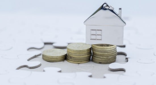 Stack of coins with a toy model house