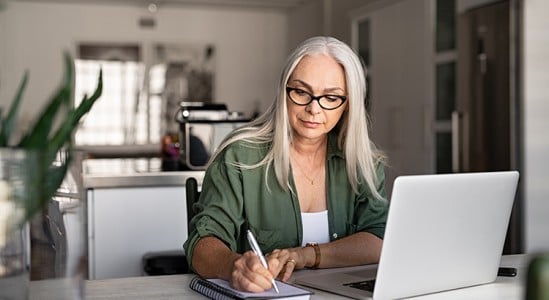 Woman using tablet and laptop in a table