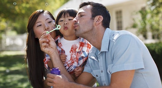 Mom, dad and daughter playing with bubbles