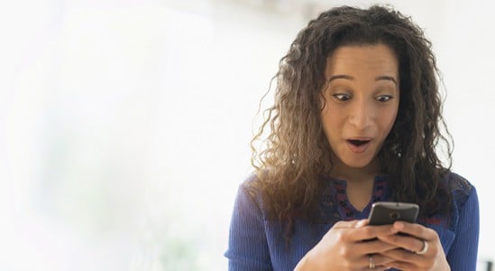 Woman shock while looking a her phone