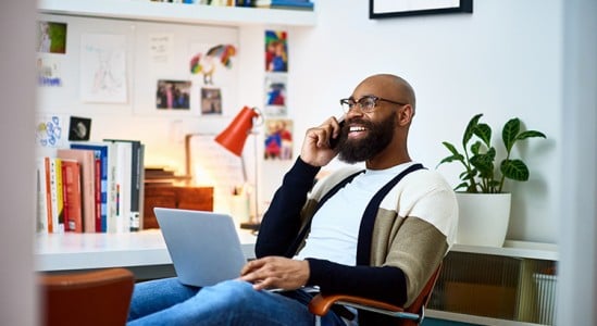 Man using laptop while in a call in the phone