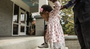 Baby girl being assisted by father