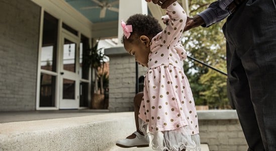 Baby girl being assisted by father