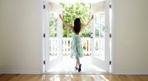 Woman dancing while opening door of house