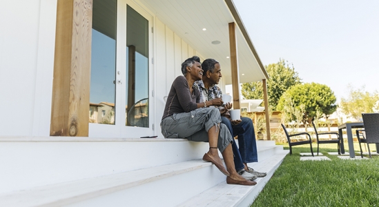 Senior couple sitting outside their home