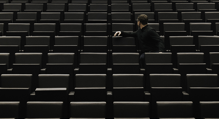 Man Sitting On Chair In Auditorium