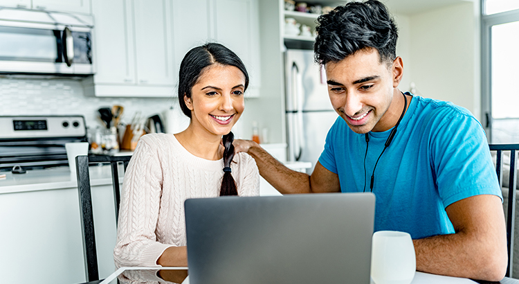 Young Indian couple working on home budget.