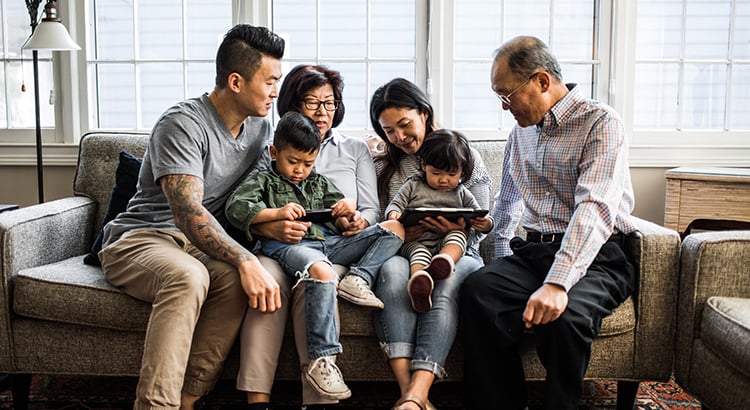 Family together in a sofa, happily talking with each other