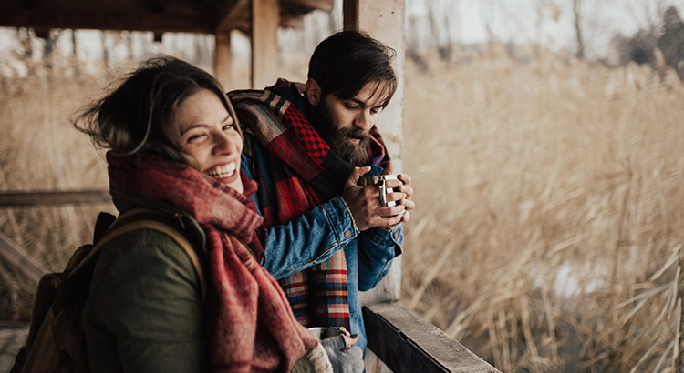 Happy couple drinking hot tea on a cold day
