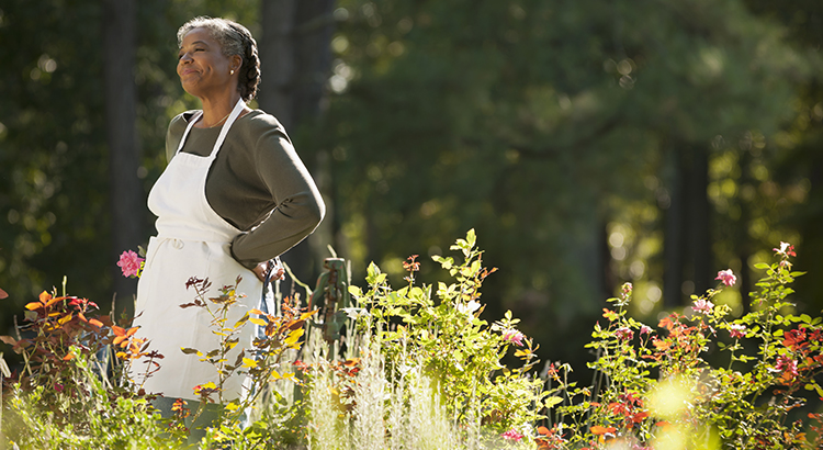 Mixed race woman wearing apron in field
