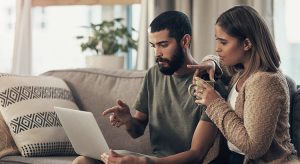 Young couple using a laptop on the sofa at home