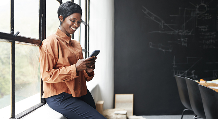 Smiling entrepreneur using phone in office meeting