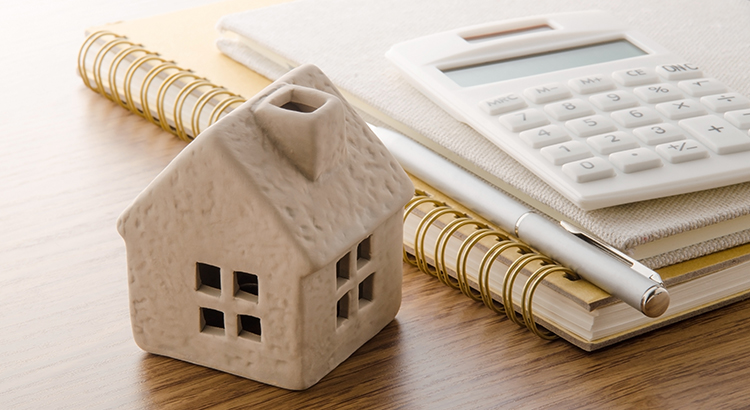 Toy house and calculator on the table