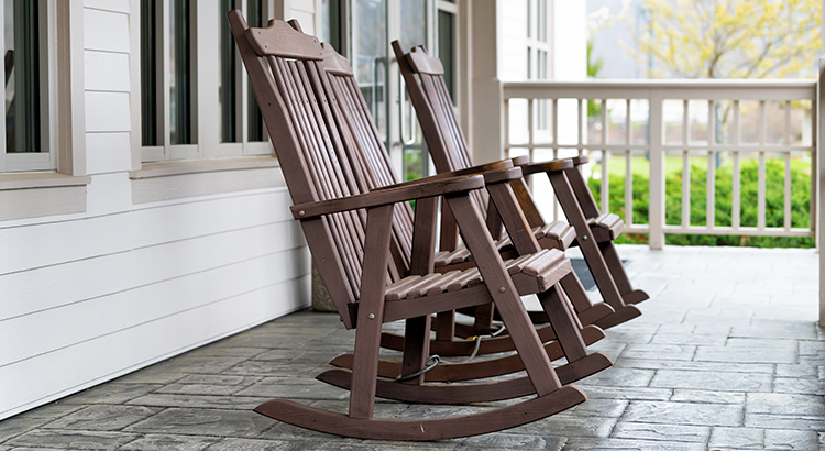 Front porch of house with brown rocking chairs and nobody in traditional american house