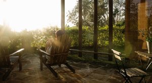 Woman relaxing with coffee and a book on veranda.