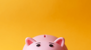 Yellow background with part of a pink "piggy" bank